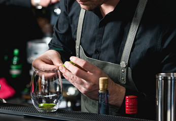 bartender making refreshing coctail with cucumber isolated on a bar background