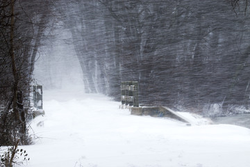 Snow blowing sideways over a wooden bridge