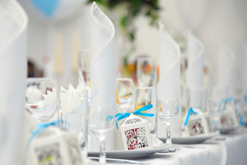 Festive table with food on a white tablecloth, set with plates and stand-up wipes. Simply a Banquet in a refined design. Purity and freshness of elite feasting. 