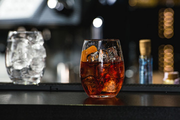 refreshing red coctail with orange isolated on a bar background