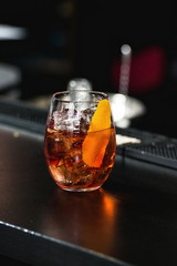 refreshing red coctail with orange isolated on a bar background