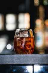refreshing red coctail with orange isolated on a bar background