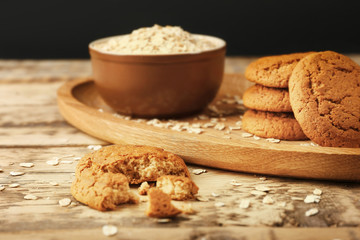 Oatmeal cookies and bowl with groats on table