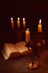 Burning candles with Bible on background
