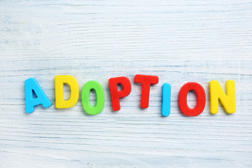 Word ADOPTION on light wooden background