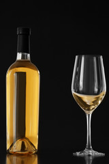 Bottle of white wine and glass on black background