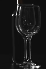 Two wineglasses and bottle on black background