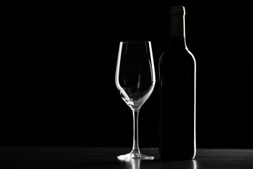Bottle of wine and glass on black background