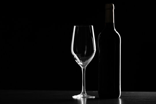 Bottle of wine and glass on black background