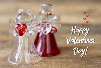 Crystal glass angel with red heart in the hands. Happy Valentine's Day text 