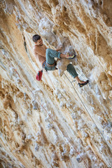 Rock climber on challenging route on cliff