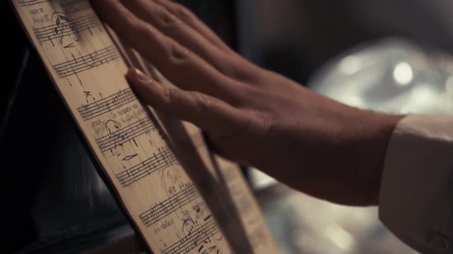 Pianist's hand leafing through notes