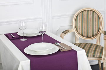 Beautifully decorated table with linen napkins, plates and glasses luxurious tablecloths
