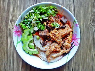 Rice noodles with spicy pork sauce (Thai  Kanom Jeen Nam Ngeaw) on wooden background