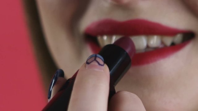 girl paints her lips close-up