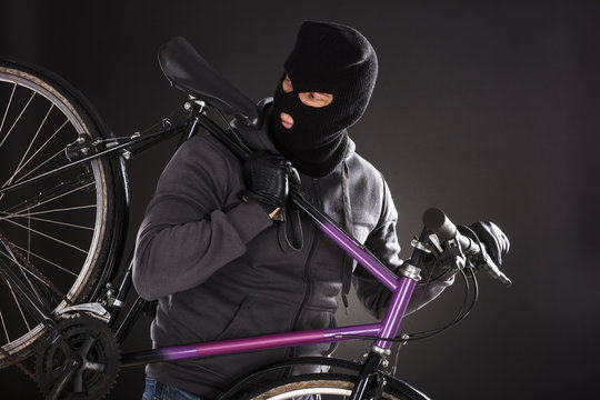 Person Wearing Balaclava Stealing A Bicycle