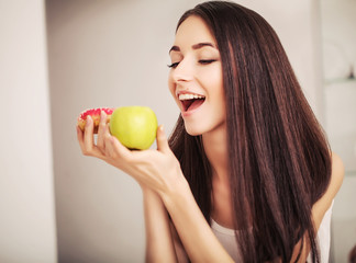Diet. A young woman holding a pizza on the scales and make a choice between an apple and a donut....