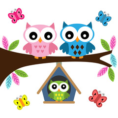 Owls family sitting on a branch