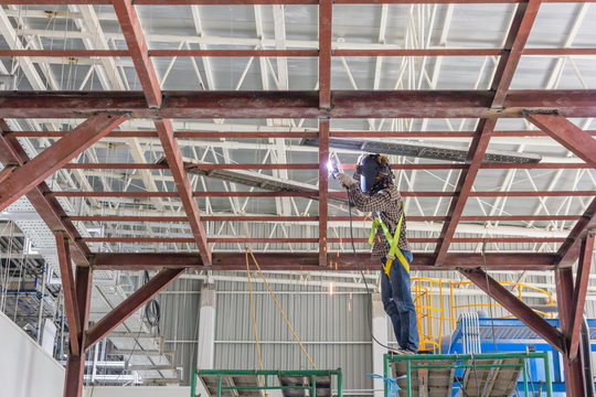 Technicians are welding steel structure. Construction site image for the background. Construction site, low safety working condition