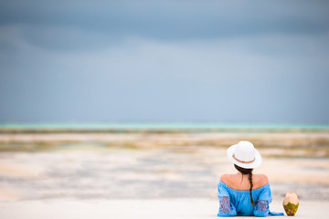 Back view of young beautiful woman on the beach during low tide