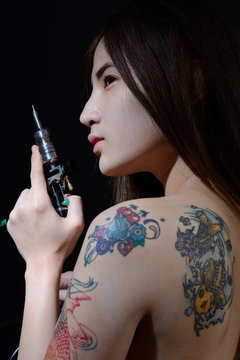 Tattoo Asian Woman Artist Holding Tattoo Machine On Dark Backgro