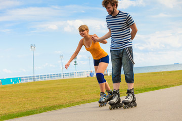 Young couple on roller skates riding outdoors