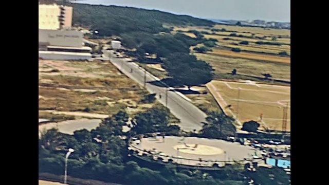 Aerial view panorama on the beach of Cala Millor Playa and park in 70's with few hotel buildings. historical restored footage. Majorca island in Spain on 1970.