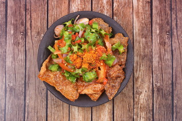 Spicy sour wing bean salad  with crispy pork served .