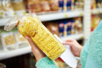 Woman with package pasta in shop
