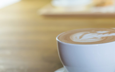 A cup of hot coffee late art in coffee shop with blur background