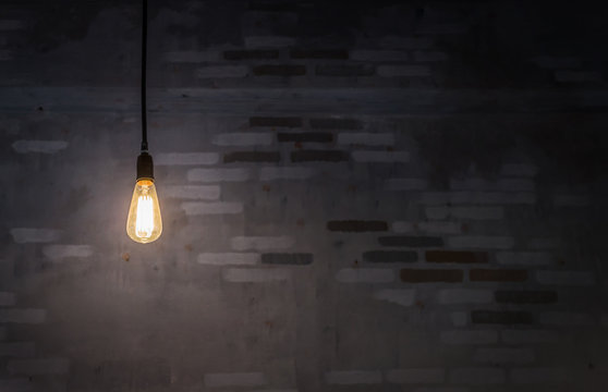 The bulb illuminated in the dark with brick background