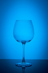 Empty wine glass on blue background