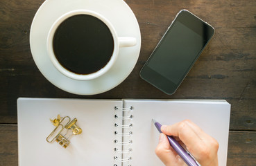 Hot cup of coffee on wooden work table