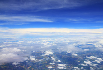 Aerial photo of land and clouds from above.