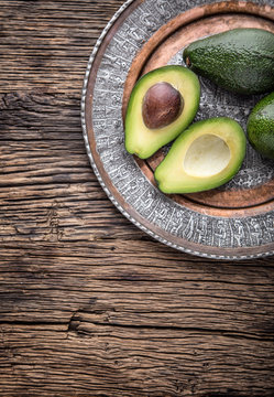 Avocado. Cut avocado on a oak wood background table. Selective focus.