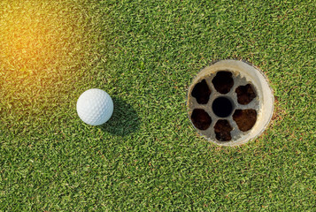 golf ball near the hole on green grass