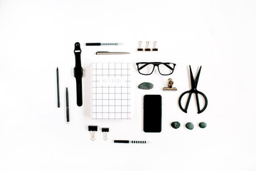 White office desk with supplies. mobile phone, glasses, notebook, scissors and office supplies on white background. Flat lay, top view office table desk.