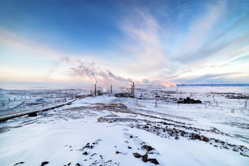 Winter landscape with the smoking pipes of steel works.