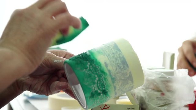 Hand of master is doing pattern on a ceramic mug. Creative Workshop. Slow motion.