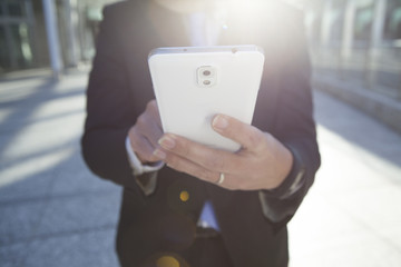 A businessman is watching a smartphone while walking