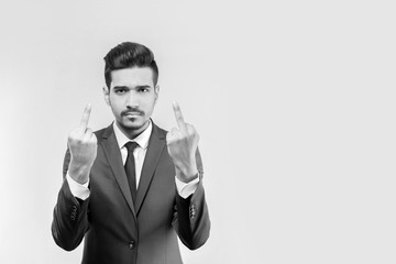 Young attractive man in a suit showing middle fingers. Monochrome
