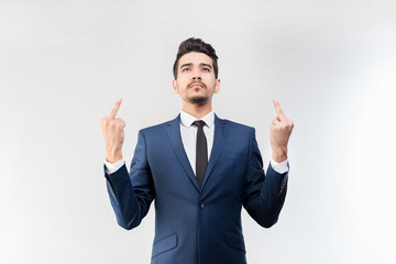 Young attractive man in a blue suit showing middle fingers on a gray background. Isolated
