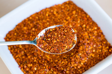 cayenne pepper spoon on red spicy background
