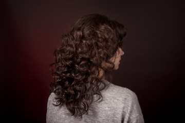 close-up portrait of girl with curly hair from a dark red scarf