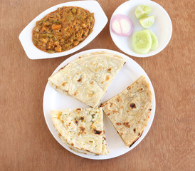 Indian food, naan, roti and kulcha, three of the types of traditional and popular Indian bread, and vegetable curry and salad.