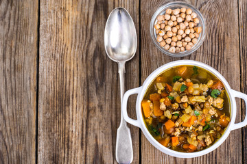 Spicy soup with chickpeas, pumpkin and curry in a white bowl on 