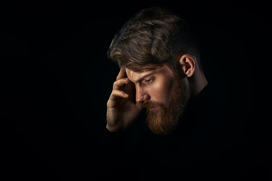 Young handsome bearded man with  beard and stylish haircut think