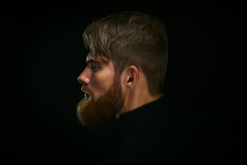 Portrait of young bearded man isolated at black background Guy w