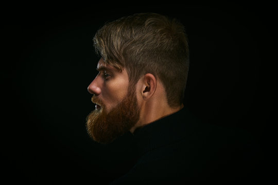 Portrait of young bearded man isolated at black background Guy w