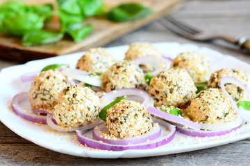 Cheese balls on a plate. Cheese balls with spices and roasted sesame seeds served with raw onion rings and basil. Easy cheese appetizer recipe. Closeup
